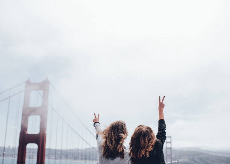 two girls taking a picture in a cloudy day in San Francisco Bridge