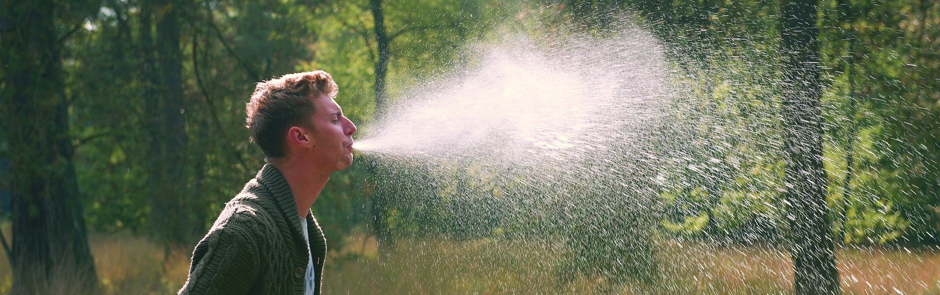 person spitting spray of liquid in the air