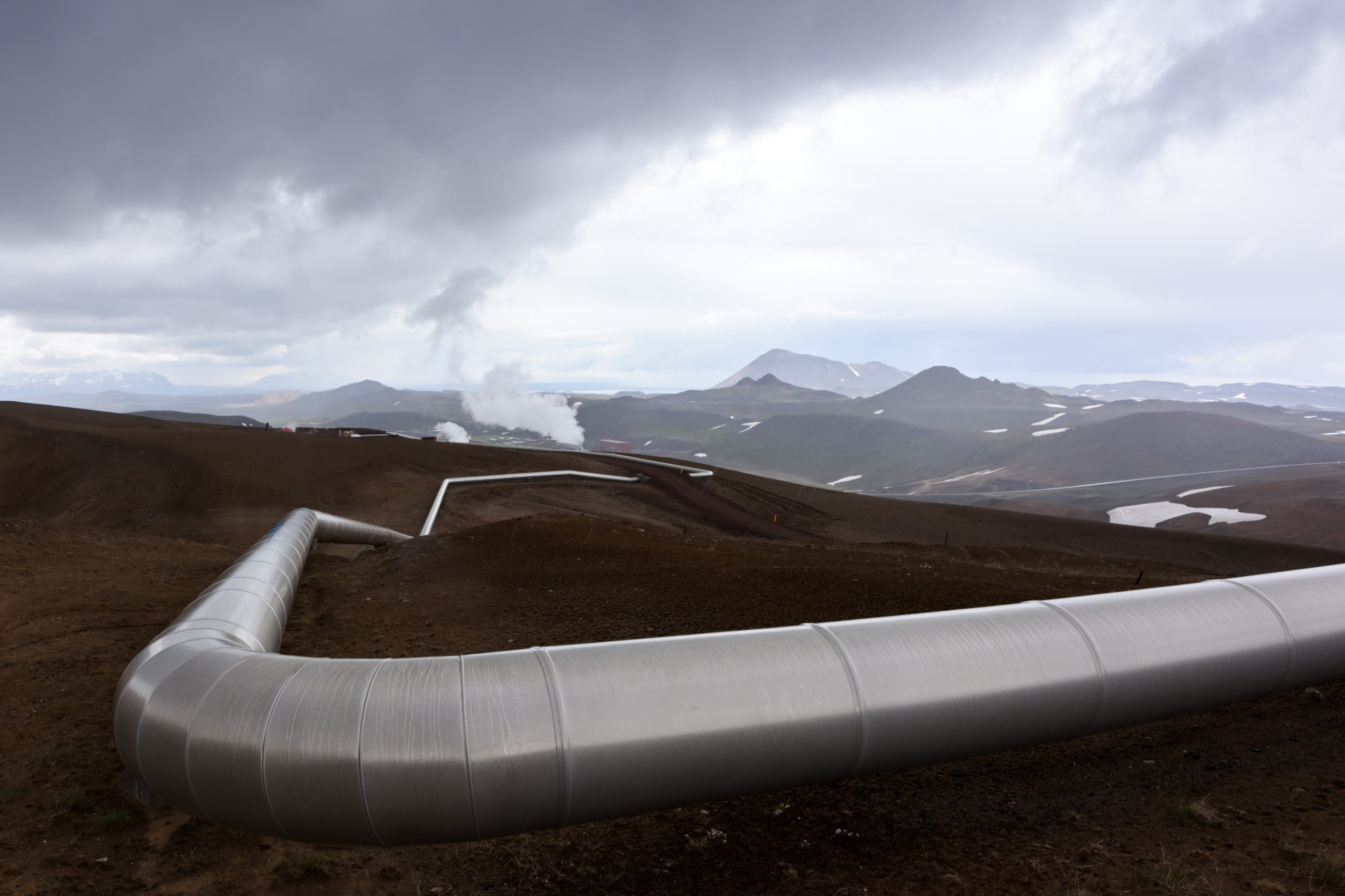 landscape with pipes in mountains. Geothermal energy in operations.