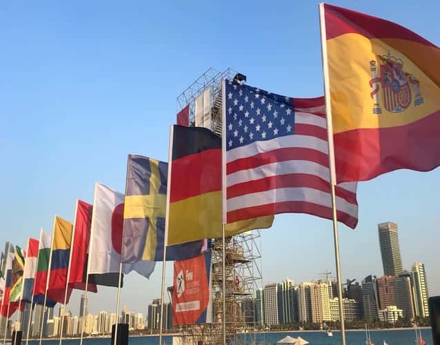 International flags displayed outdoors with city skyline in the background