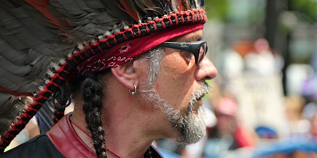 Native amercian protestor with headdress and glasses