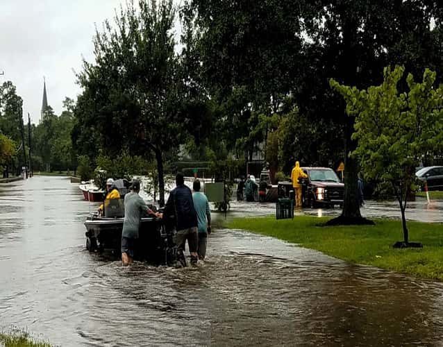 flood: pushing a boat on a street