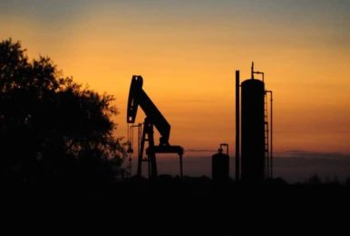 oil derrick pump and tank photo taken during sunset