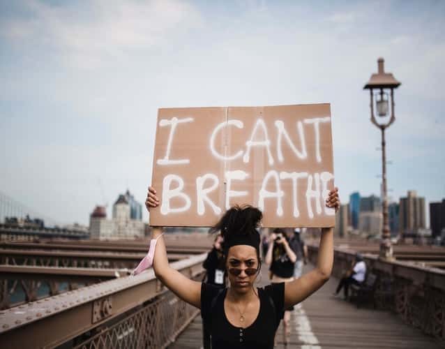 woman of color holding a I can't breath sign
