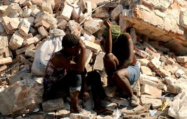 Haitian women sit on rubble from a collapsed building in Port-au-Prince, Haiti, after a 7.0-magnitude earthquake struck the region on January 12, 2010. Source: U.S. Air Force