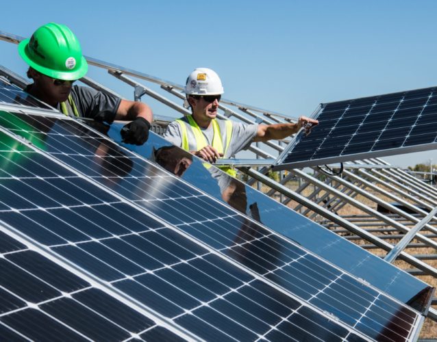 men holding solar panels